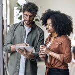 Two people discussing work on a tablet.