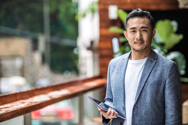 Man holding tablet in outdoor setting