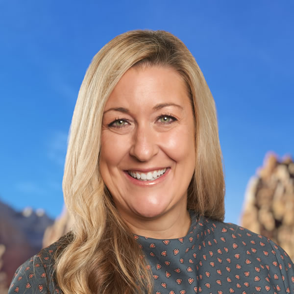 Mulher sorridente com fundo de montanhas