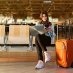 Viajante com portátil e mala no terminal do aeroporto.
