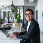 empresário chinês num café contemporâneo a utilizar um computador portátil