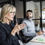 Reunião de negócios com dois profissionais a discutir.
