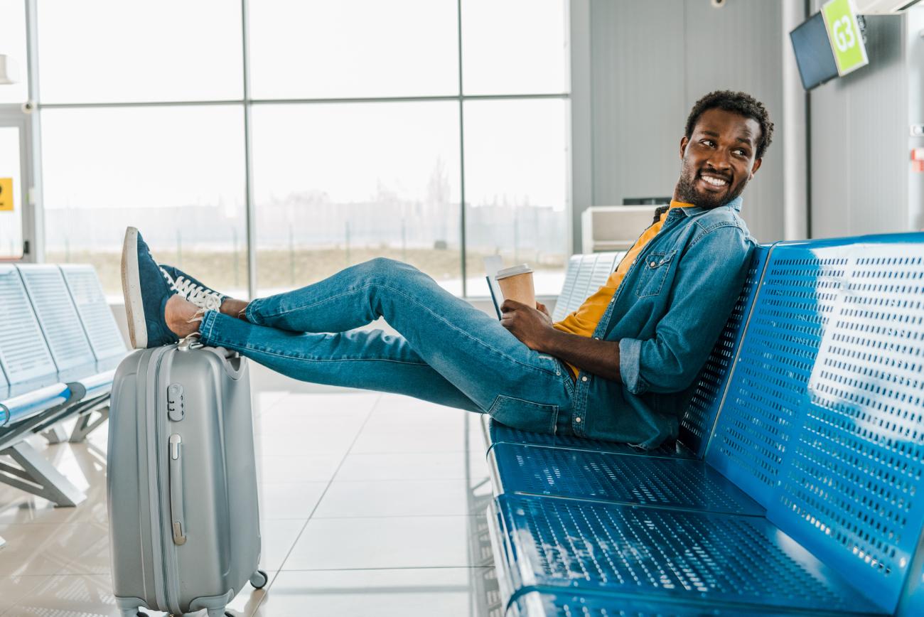 happy african american man sitting in airport with 2023 11 27 05 16 04 utc (1)