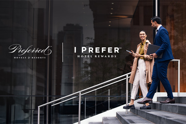 Business travelers descending hotel steps beside I Prefer logo
