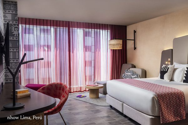 Modern hotel room with stylish decor and large windows.