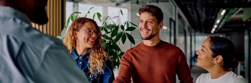 Coworkers smiling and talking in a modern office