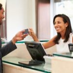 Receptionist assisting guest at hotel front desk