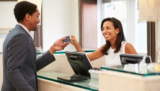 Receptionist assisting guest at hotel front desk