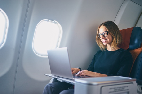 Woman working on laptop during airplane flight
