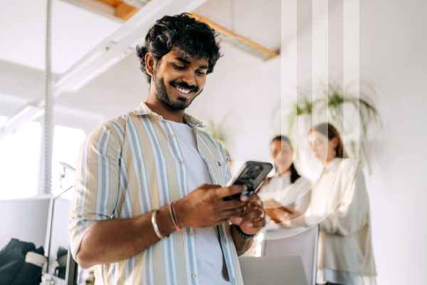 Smiling man using smartphone in modern office