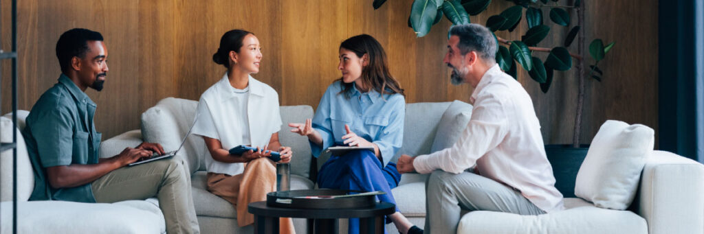 Four colleagues having a meeting on office couches