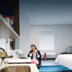 Woman working in modern hotel room with laptop.