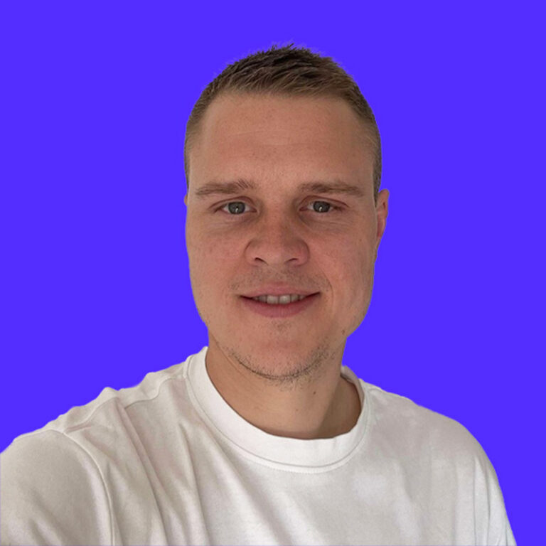 Smiling man in white shirt against purple background