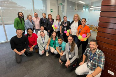 Office team posing with colorful balloons