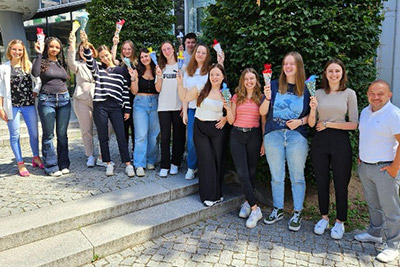 Group of young adults holding red ice cream bars outdoors