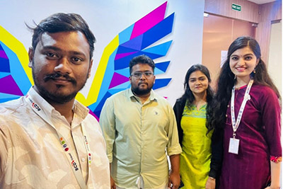 Four coworkers pose for a colorful office selfie