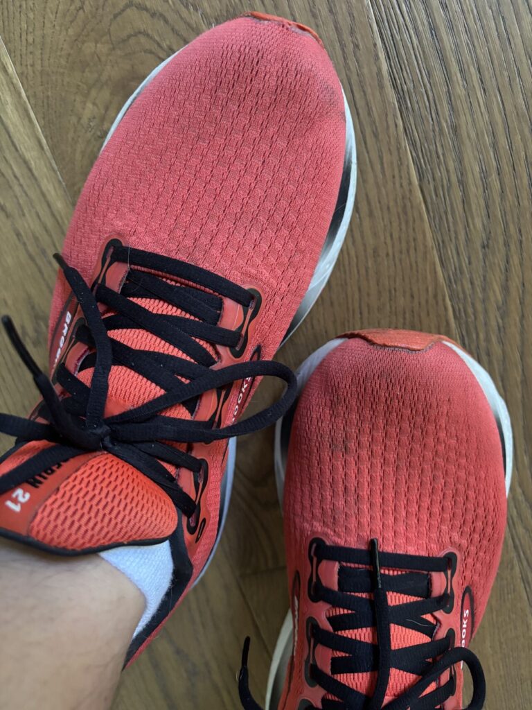Red running shoes on wooden floor