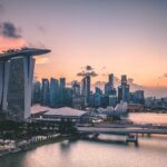 Singapore skyline at sunset with iconic buildings.