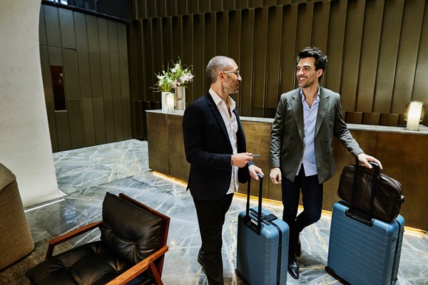 Two businessmen with luggage in hotel lobby
