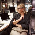 Smiling woman sitting at desk in modern office.