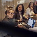 businesswoman discussing with businessman by colleagues in board room