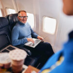Man working on laptop during airplane flight