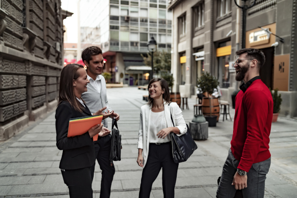 Group of professionals chatting on a city street.