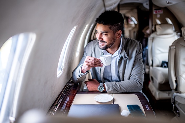 Man enjoying coffee inside a private jet cabin