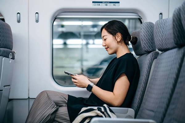 Woman using smartphone while seated on a train