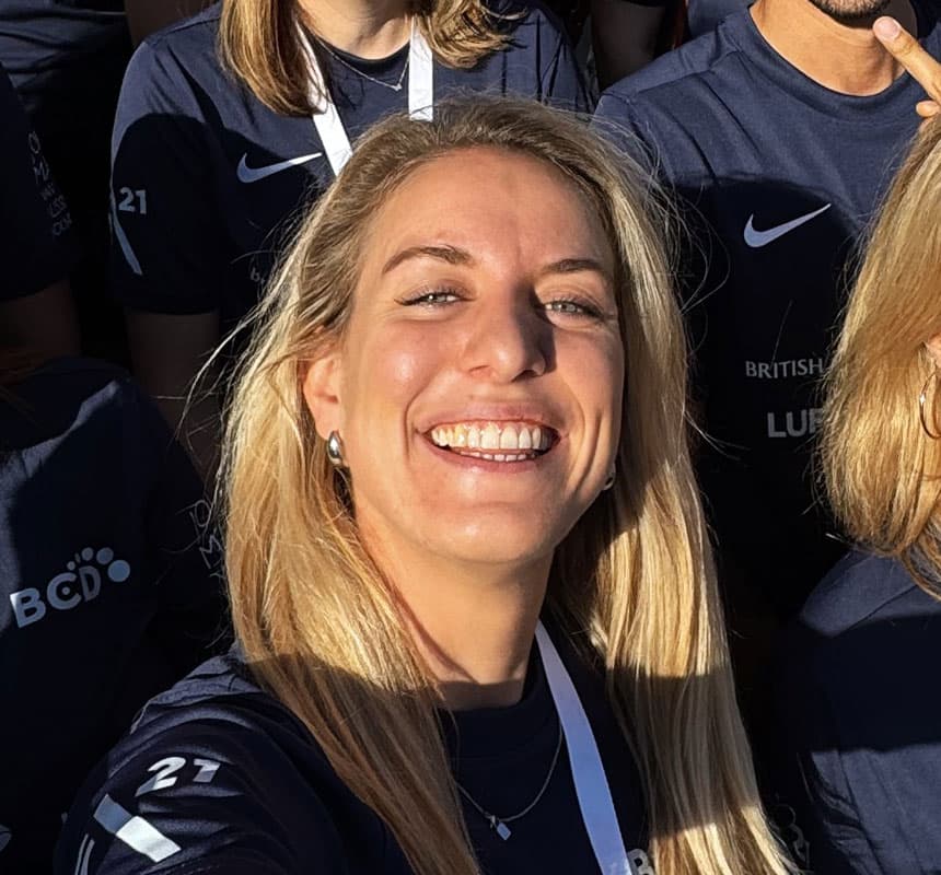 Smiling blonde woman in navy team shirt