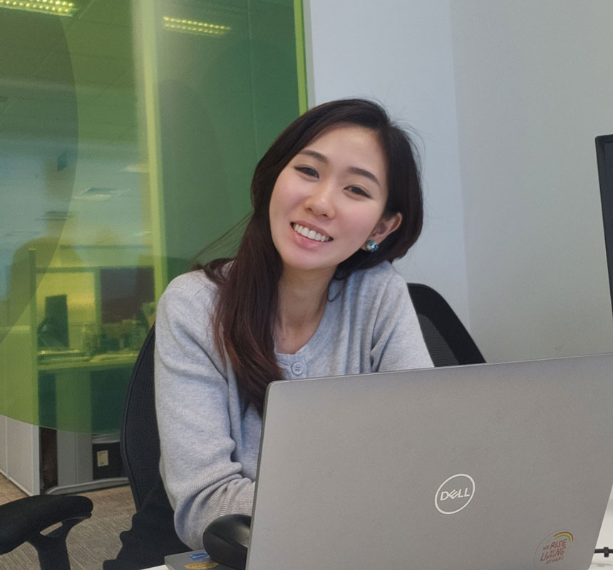Smiling woman seated behind Dell laptop in office