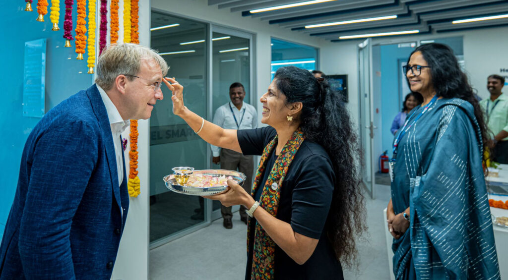Woman applies ceremonial mark to guest in decorated office