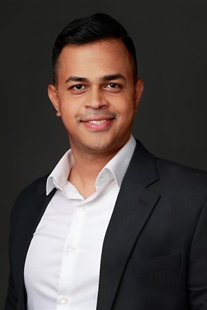 Professional headshot of man in dark blazer