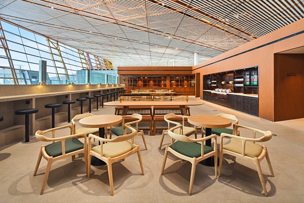Modern airport lounge with wooden seating and bar