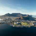 Aerial view of coastal city and mountains.