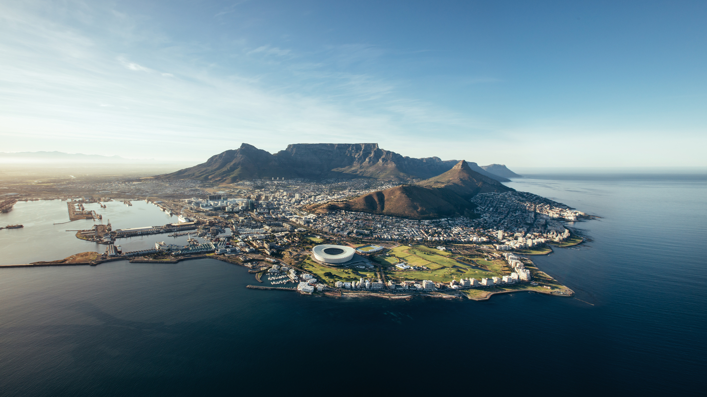 Aerial view of coastal city and mountains.