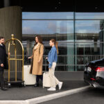Travelers with luggage at airport pickup zone