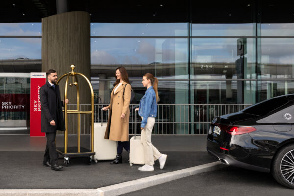 Travelers with luggage at airport pickup zone