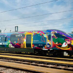 Colorful train with vibrant graphics on tracks.