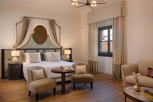 Elegant hotel bedroom with canopy bed and seating area