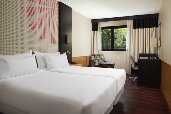 Modern hotel room with twin beds and desk