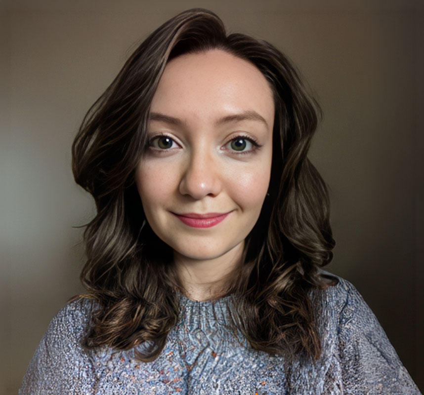 Smiling woman with wavy dark hair in gray sweater