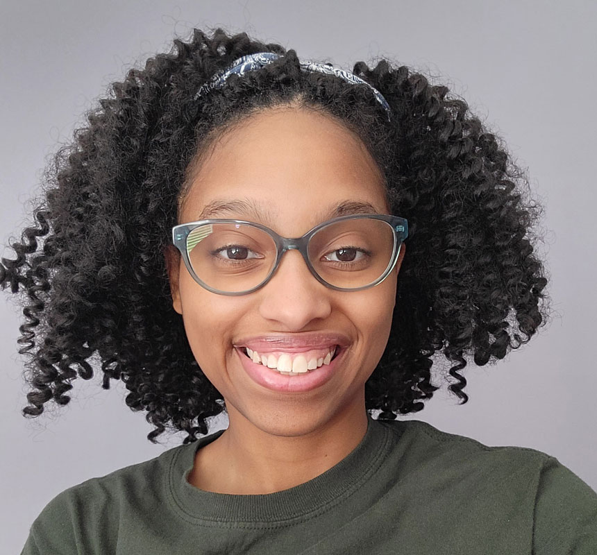 Smiling woman with curly hair and glasses