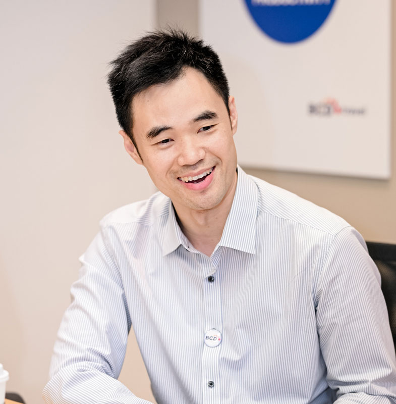 Smiling man in striped shirt seated at office desk