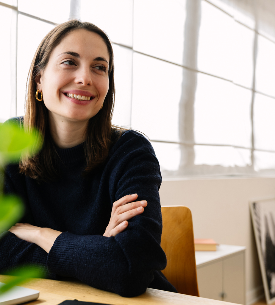 Smiling woman sitting at desk by window