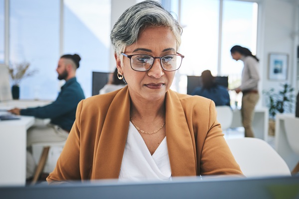 Professional woman wearing glasses works at office computer