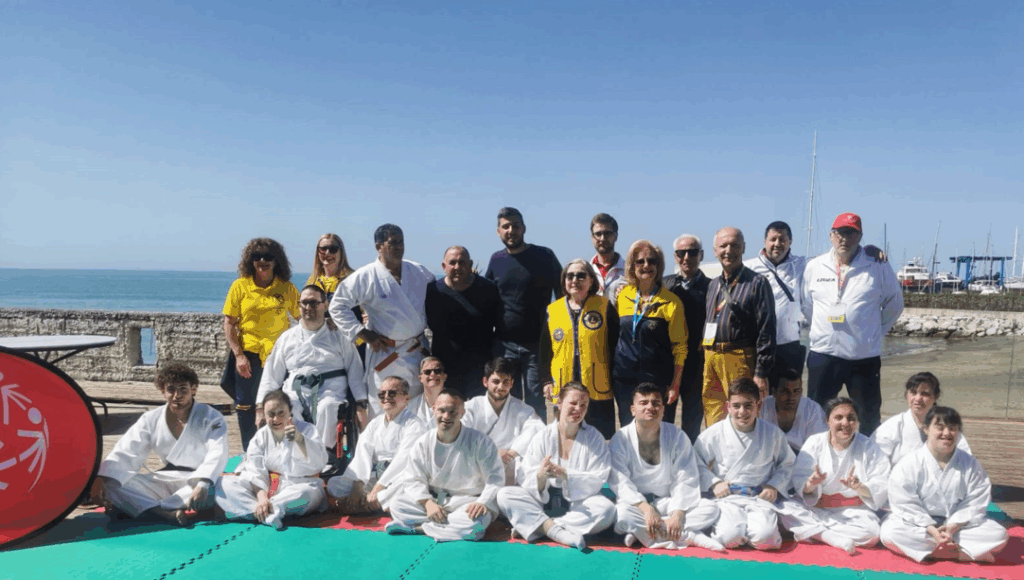 Group photo of martial arts participants by the sea.