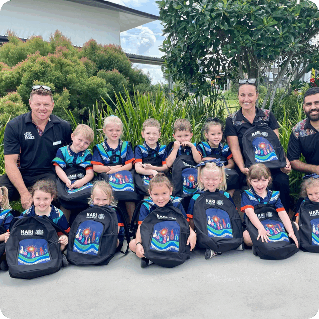 Group of children and adults with school bags.
