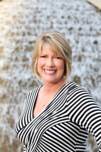 Smiling woman with striped shirt outdoors