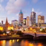 Melbourne city skyline at dusk with river view.